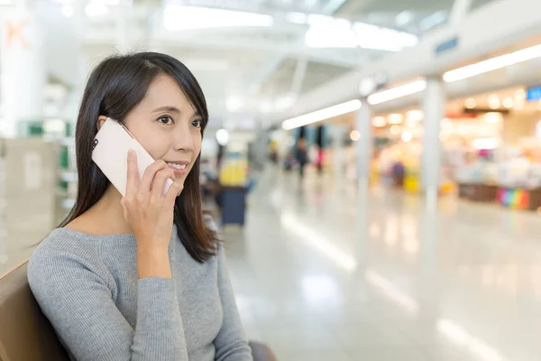 Woman talk to cellphone in departure hall — Stock Photo, Image