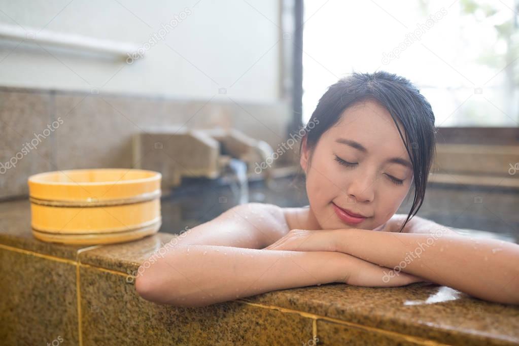 Woman enjoy hot springs in Japanese onsen