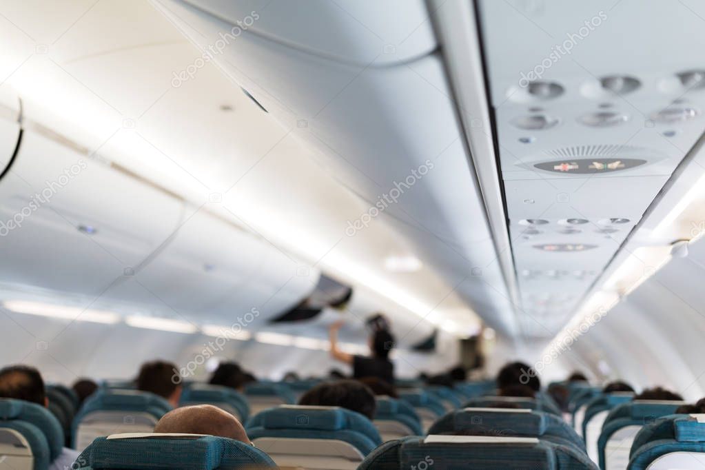 Plane cabin interior with passengers 