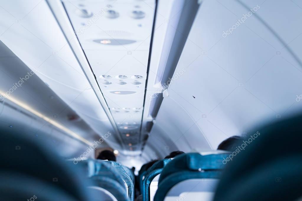 Airplane cabin with seats and passengers