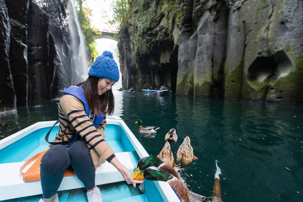 Mulher alimentando pato e sentado no barco — Fotografia de Stock