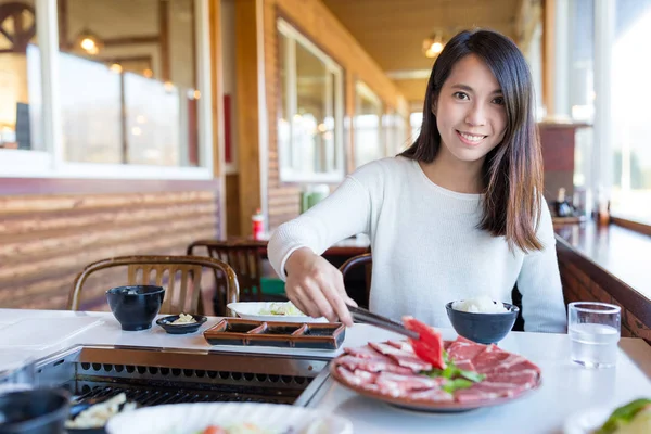 Mujer teniendo carne barbacoa en restaurante japonés — Foto de Stock