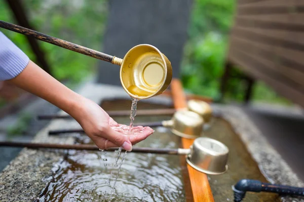 Woman washes her hand in fountain — Stock Photo, Image