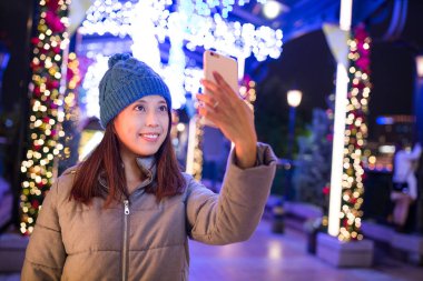 Selfie tarafından cep telefonu Noel dekorasyonu ile çekici kadın