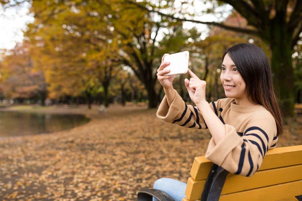 Frau fotografiert mit Handy im Park — Stockfoto