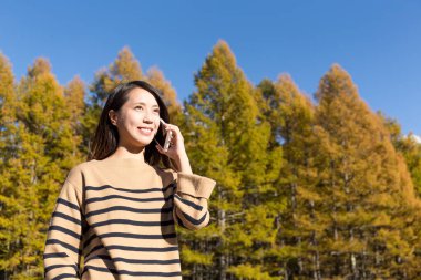 Kadın cep telefonuyla konuşuyor.
