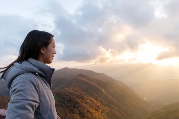 Γυναίκα κοιτάζοντας το ηλιοβασίλεμα στο βουνό — Φωτογραφία Αρχείου