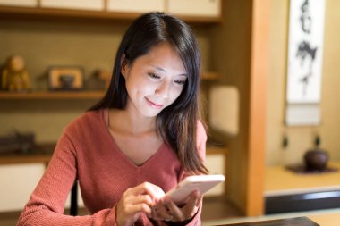 Çay evde cep telefonu kullanan kadın