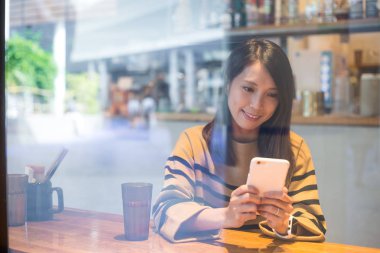 kahve dükkanında cep telefonu kullanan kadın