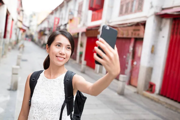 Vrouw met behulp van mobiele telefoon te nemen selfie in Macao stad — Stockfoto