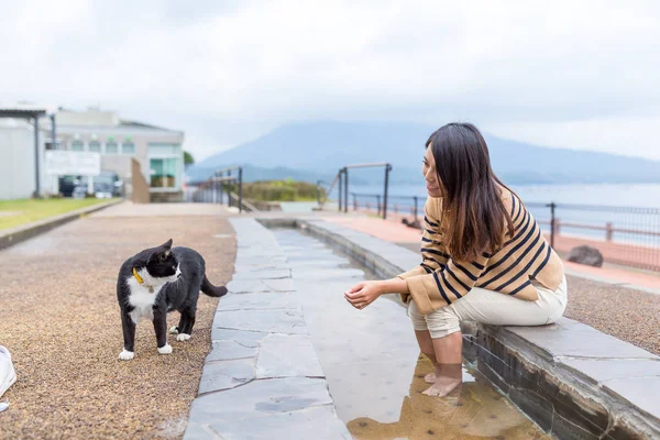 Mulher joga com gato de rua — Fotografia de Stock