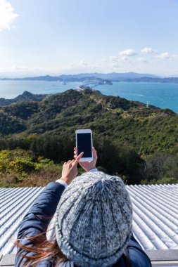 fotoğraf çekmek için cep telefonu kullanan kadın