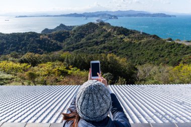 Fotoğraf çekmek için cep telefonu kullanan kadın