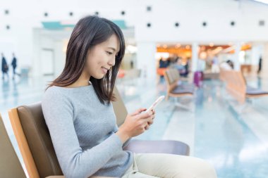 Havaalanında cep telefonu kullanan kadın