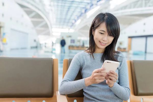 Vrouw met behulp van GSM-telefoon in luchthaven — Stockfoto