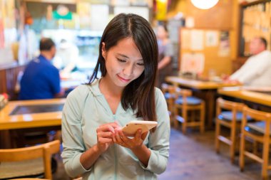 restoranda cep telefonu kullanan kadın