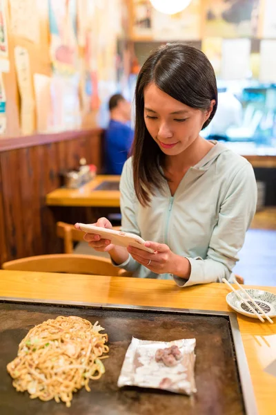 Donna che scatta foto su Okonomiyaki nel ristorante — Foto Stock