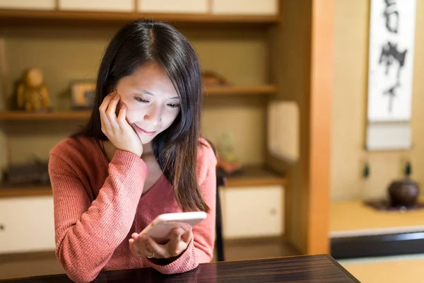Kadın Japon restoranı cep telefonu üzerinde okuma