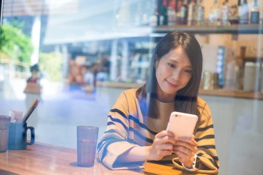 Cep telefonu kafede izlerken kadın