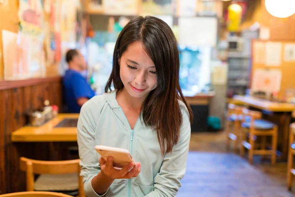 Japon lokantasında cep telefonu kullanan kadın