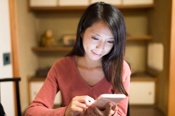 Woman looking at cellphone in Japanese restaurant