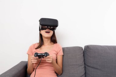 Kadın evde VR aygıtıyla oyun oynuyor