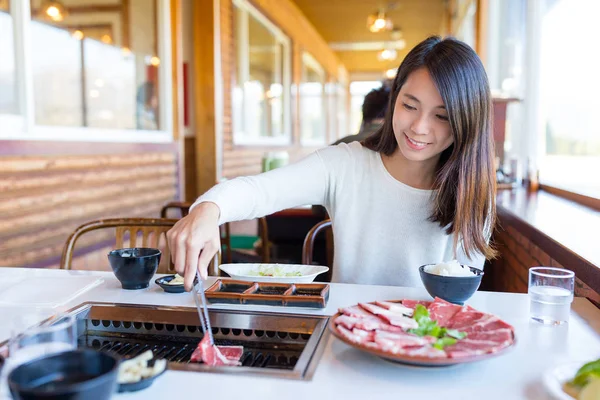 Woman eating barbecue beef in restaurant — Stock Photo, Image