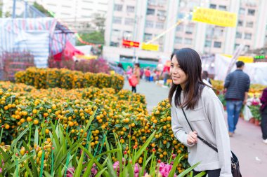 Asyalı kadın seçme narenciye saksı