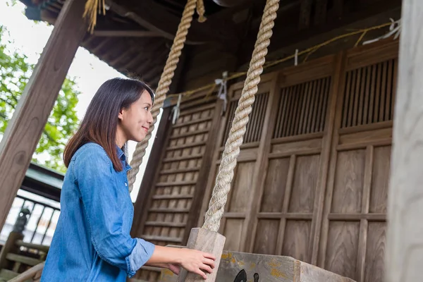 Donna che suona la campana nel tempio giapponese — Foto Stock