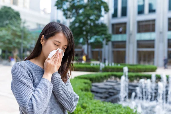 Mujer joven estornudar al aire libre — Foto de Stock