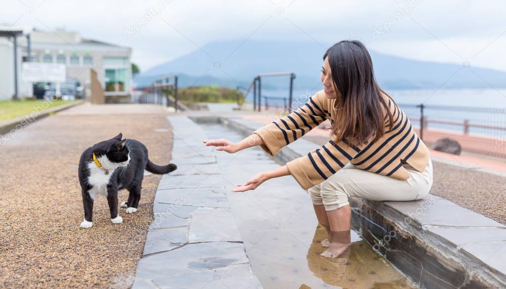 Woman enjoy foot onsen and plays with cat
