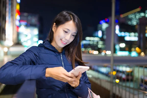 Mulher usando celular à noite — Fotografia de Stock