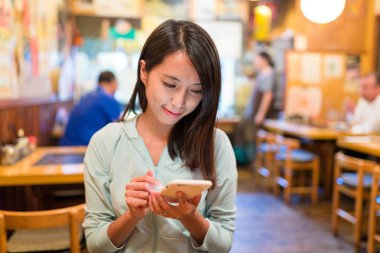 İçinde Restoran cep telefonu kullanan kadın