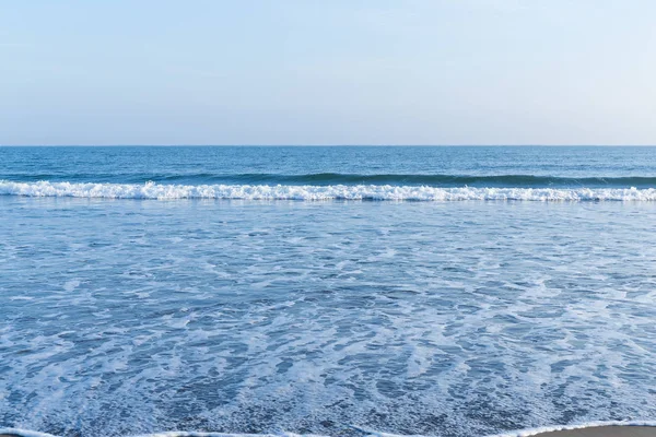 Costa da praia com ondas ao sol — Fotografia de Stock