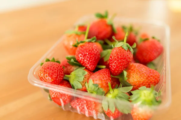 Reife Erdbeeren in Packung auf dem Tisch — Stockfoto