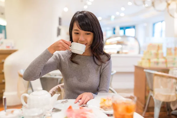 Femme buvant du thé dans un magasin de gâteaux — Photo