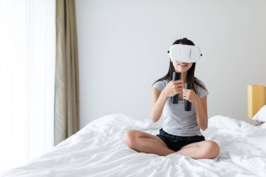 Kadın sanal gerçeklik cihazda oyun oynuyor