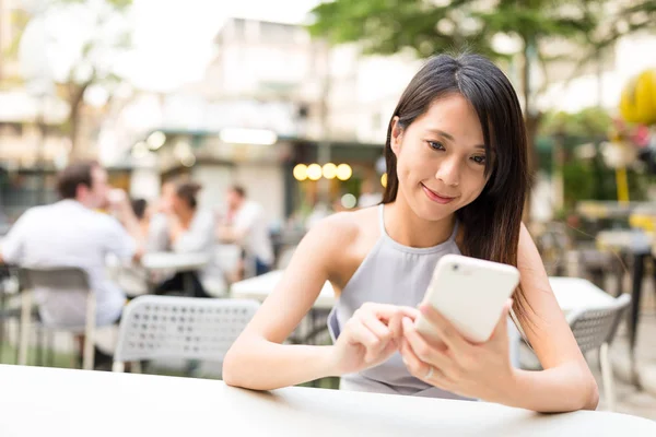 Cep telefonu açık restoranda kullanan kadın