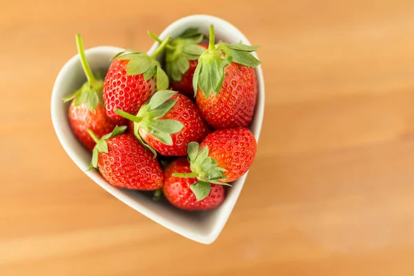 Strawberries in heart shape bowl — Stock Photo, Image