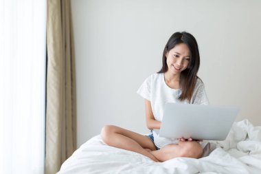 Evde dizüstü bilgisayar kullanan kadın