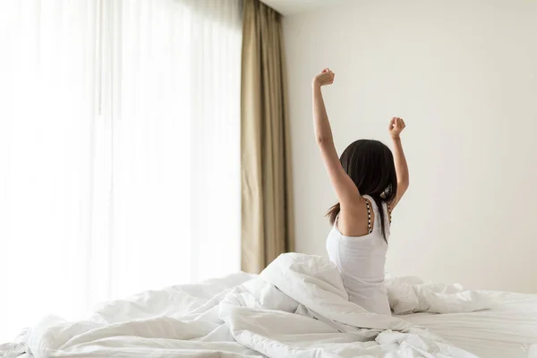 Vrouw stretching in bed na wakker worden — Stockfoto