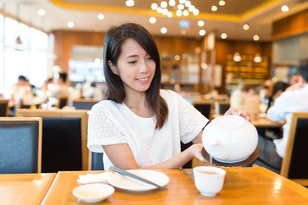 Mulher derramando chá quente no restaurante chinês — Fotografia de Stock