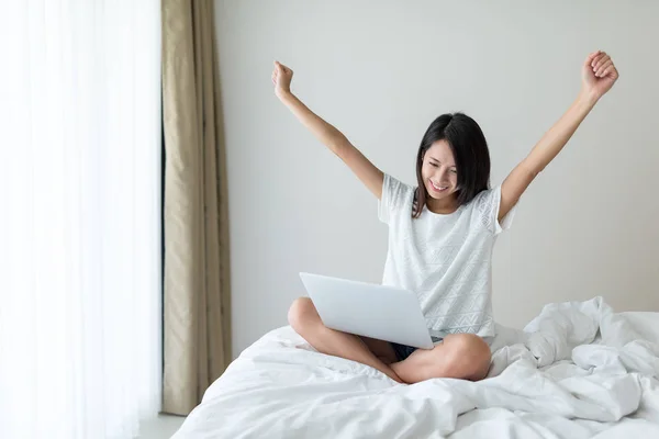 woman raising hand up when finish working on laptop computer