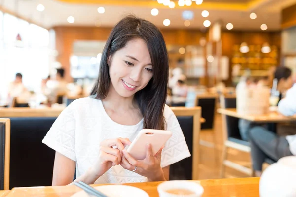 Женщина с мобильного телефона в китайском ресторане — стоковое фото