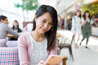 Kafede cep telefonu kullanan kadın