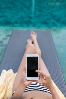 Güneşlenmek üzerinde rahatlatıcı ve cep telefonuyla kadın