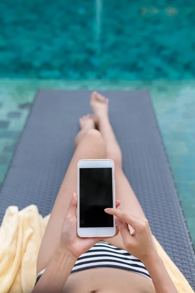 Donna rilassante sul bagno di sole e utilizzando il telefono cellulare — Foto Stock