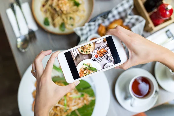 Mujer tomando fotos en el teléfono celular en el plato —  Fotos de Stock