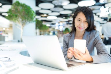 cep telefonu ve dizüstü bilgisayar kullanan kadın