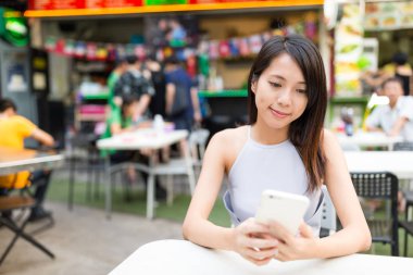 Cep telefonu açık pazarda kullanan kadın